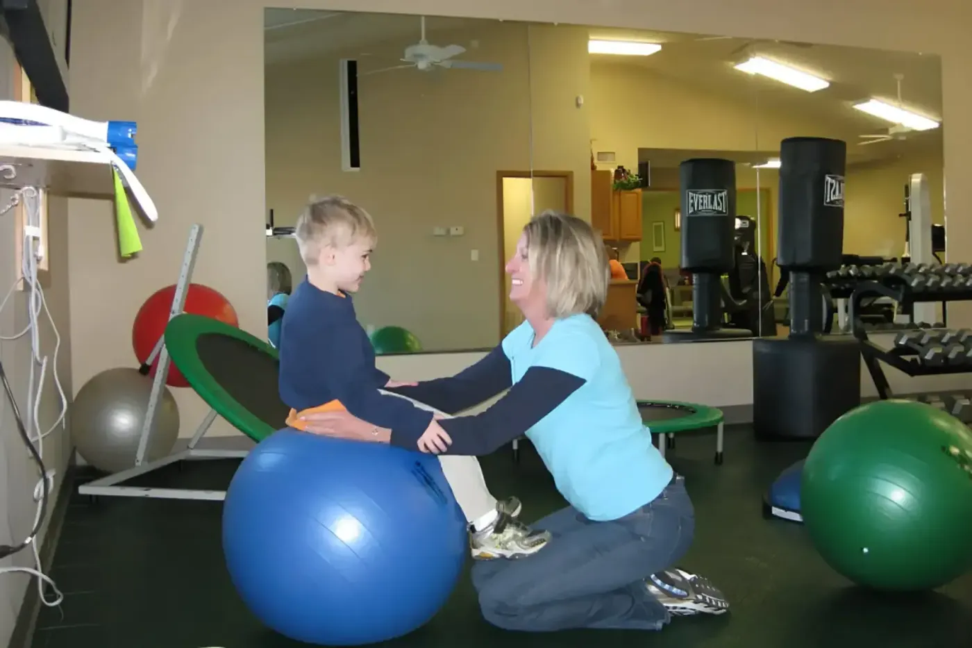 Physical therapist working with a child on balance and coordination during pediatric therapy