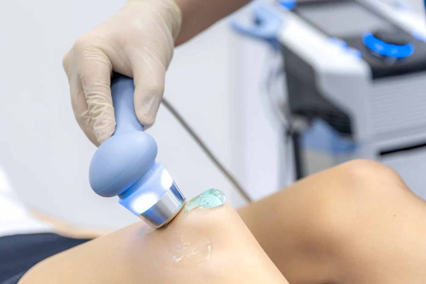 Therapist applying a therapeutic ultrasound head to a patient during treatment