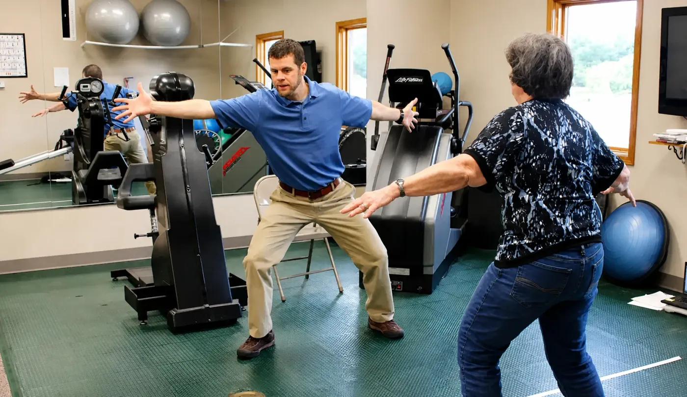 Therapist coaching a patient through balance and gait training for Parkinson's
